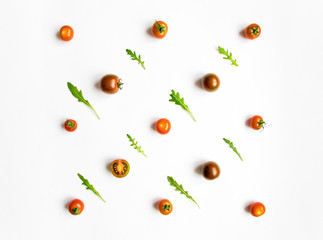 Cherry tomatoes and rocket salad leaves pattern on white background. Flat lay