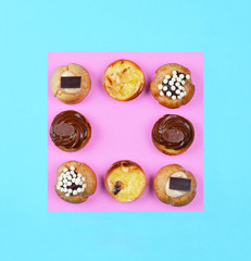 Delicious various pastries on trendy blue background.