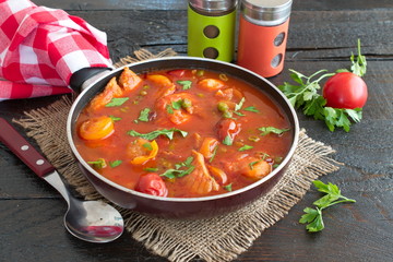 Fish fillet cooked in tomato sauce with green peas and cherry tomatoes on a plate on a wooden background. Healthy eting concept. Easy cooking.