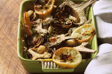 fried artichokes with garlic and lemon on pan on rustic table