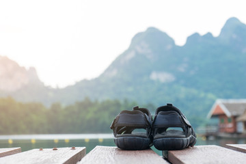 couple hiking sandals on mountain near river on nature background. Trekking shoes of family, man and woman. Travel healthy active lifestyle. Outdoor freedom.