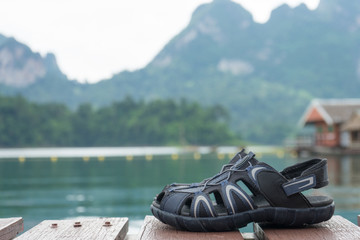 couple hiking sandals on mountain near river on nature background. Trekking shoes of family, man...