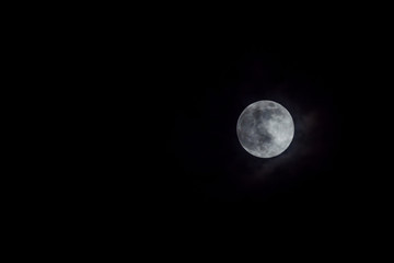 Mystic full moon in night sky with clouds.