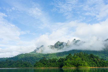 Obraz premium Mountains and lake in mist with blue sky