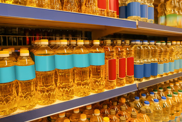 Bottles with cooking oil on shelves in supermarket