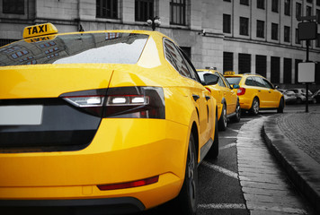 Fototapeta na wymiar Rear view of yellow taxi on street