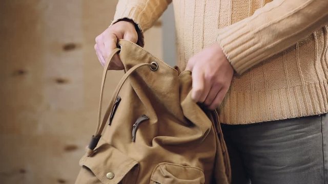Weary tourist unpacking his marching backpack after long and exhausting trip