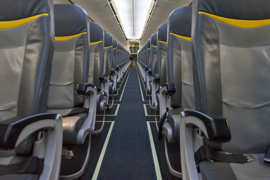 Passenger Seat, Interior Of Airplane And Stewardess Walking The Aisle In Background. Travel Concept,vintage Color