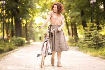 Fototapeta premium Beautiful young woman with bicycle, outdoors