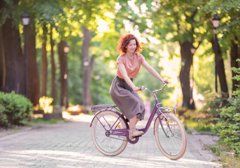 Obraz na płótnie Canvas Beautiful young woman with bicycle, outdoors