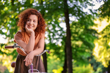 Beautiful young woman with bicycle, outdoors