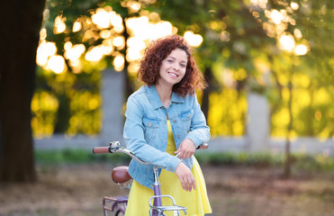 Beautiful young woman with bicycle, outdoors