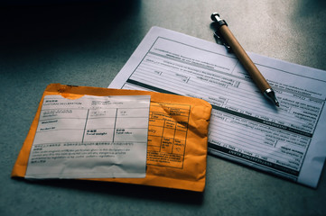 Blank shipping envelope with blank documents and pencil on the table.