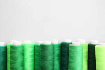 Green sewing threads on white background