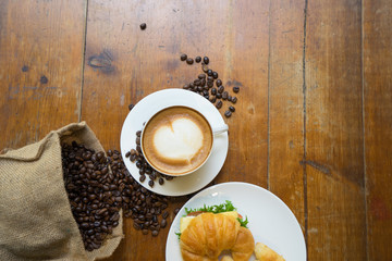 Breakfast with cup of coffee, fresh croissantson white wooden background, selective focus