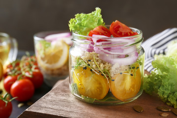 Vegetable salad with quinoa served in glass jar on kitchen table