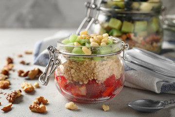 Fruit salad with quinoa served in glass jar on kitchen table