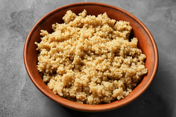 Cooked quinoa in bowl on grey background