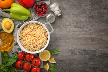Composition with cooked quinoa and fresh products on grey background