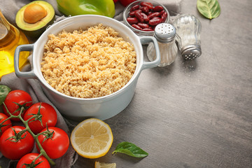 Composition with cooked quinoa and fresh products on grey background