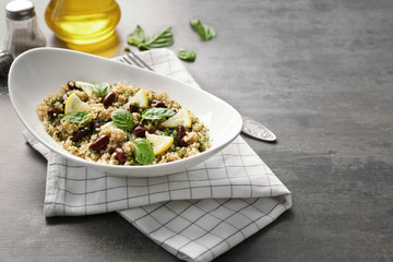 Salad with quinoa, basil and beans served in bowl on grey background
