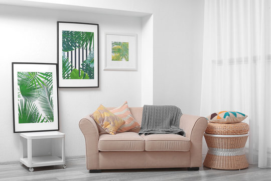 Modern living room design with framed pictures of tropical leaves