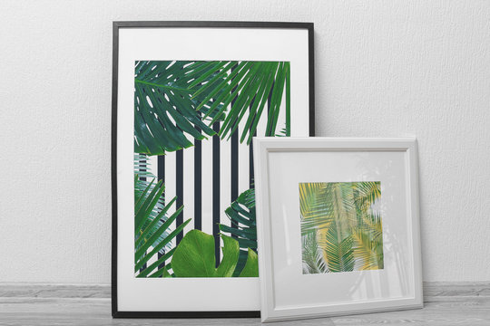Framed pictures of tropical leaves on white wall background