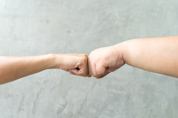Closeup of two touching with punches hands of big hand and little hand