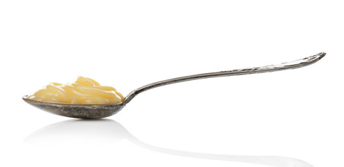 Metal spoon with vanilla pudding on white background