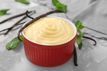 Vanilla pudding in red bowl on grey background