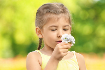 Cute little girl with flowers outdoors