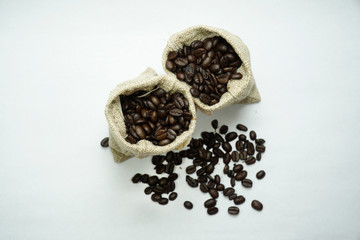 Fototapeta na wymiar Coffee beans inside the sack bag on white isolated background.