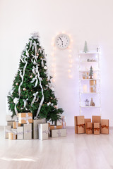 Decorated Christmas tree with gifts in light room