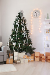 Decorated room with beautiful Christmas tree and gifts