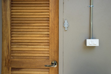 Beige rocker light switch with tree buttons and woman door toilet