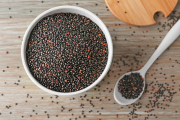 Black quinoa in ceramic bowl and spoon on kitchen table