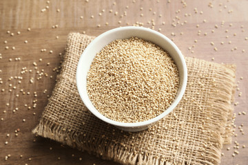 White quinoa in ceramic bowl on kitchen table