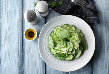 Plate with fresh cucumber salad on table