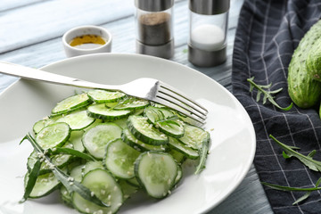 Plate with fresh cucumber salad on table, closeup