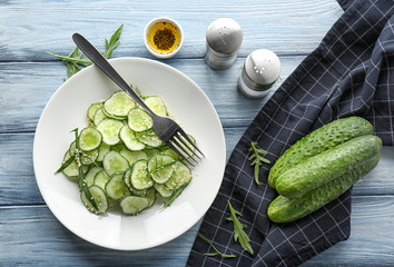 Plate with fresh cucumber salad on table