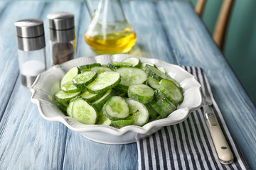 Slices of cucumber in plate on table