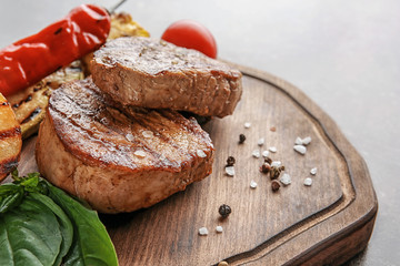 Composition with tasty grilled steaks on table, closeup
