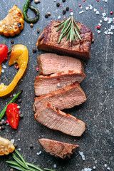 Delicious sliced steak with vegetables on table