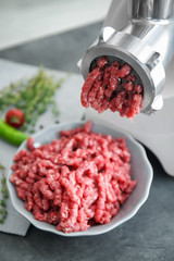 Meat grinder with fresh forcemeat on kitchen table
