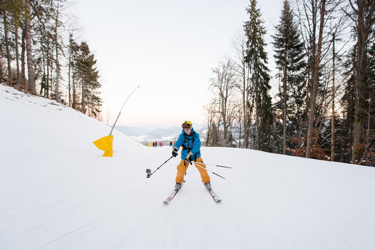 Man on skis moving down the mountain slope and taking selfie with stick on the winter ski resort recreation travelling tourism vacation extreme adrenaline