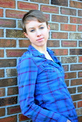 Female beauty expressions against a wall outside.