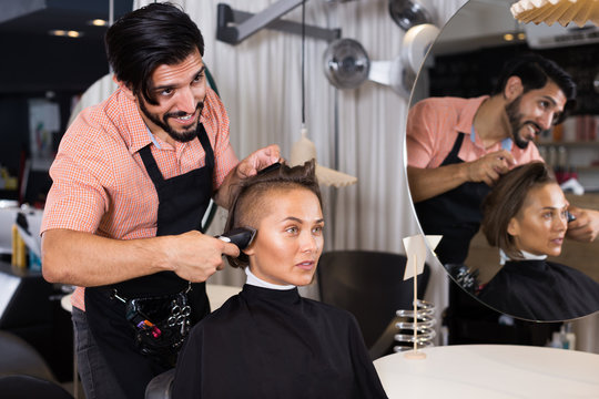 Adult man professional shaving woman's hair