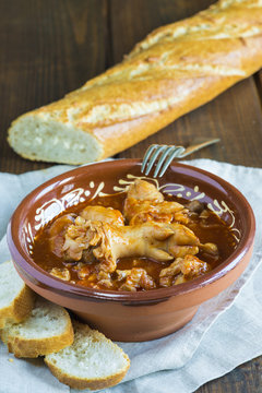 Cuenco de barro tradicional con manitas de cochinillo en salsa, carne de cerdo para el aperitivo o la comida