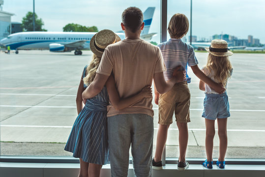 family looking out window in airport