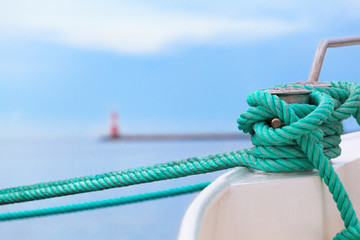 Before put out to Sea Voyage / Green rope fix boat with knot at bollard in harbor - pier,...